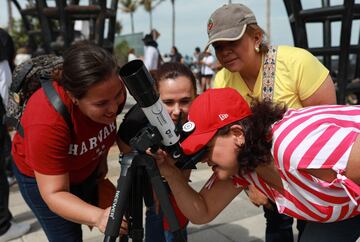 La gente se reúne para observar el sol en el Malecón, un día antes de un eclipse solar total en Mazatlán, México.