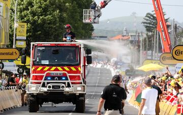 Un camión de bomberos lanza agua a los aficionados que presenciaban la etapa 10 del Tour de Francia. Los
seguidores recibieron con entusiasmo los manguerazos, que les sirvieron para en alguna medida paliar los efectos de las altas temperaturas que en la ola de calor se registraron en buena parte de Europa.