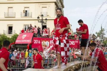 El defensa del Sevilla Coke se baña junto a otros compañeros en la plaza de la Puerta de Jerez, durante el paseo triunfal que ha realizado el equipo esta tarde para festejar y ofrecer a la ciudad su quinta Liga Europa conseguida el pasado miércoles en Basilea (Suiza)