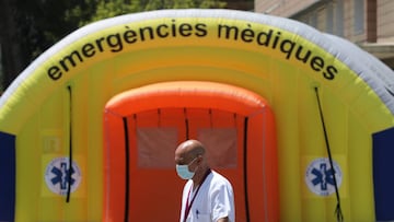 A health worker wearing a protective mask walks past a field hospital outside Arnau de Vilanova hospital, after a judge barred Catalan authorities from enforcing a stricter lockdown to residents in the city of Lleida, to control the coronavirus disease (COVID-19) outbreak, in Lleida, Spain, July 13, 2020. REUTERS/Nacho Doce