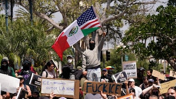 Una persona exhibe una bandera de Estados Unidos y México mientras manifestantes asisten a una manifestación contra las redadas federales de inmigración, en el centro de Los Ángeles, California, EE. UU.