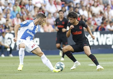 El jugador del Atlético de Madrid, João Félix, controla el balón ante el jugador del Leganés, Rubén Pérez. 
 