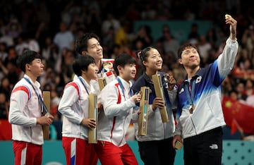 Las medallistas de China, Corea del norte y corea del sur posan en una selfie en el podio después de ganar el torneo de dobles mixtos de tenis de mesa.