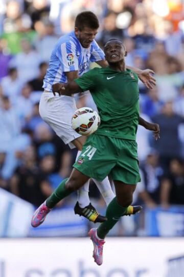El centrocampista del Málaga Ignacio Camacho (i), salta por el balón ante el centrocampista mozambiqueño del Levante Simao Mate, durante el encuentro de la tercera jornada de Liga en Primera División disputado en el estadio de La Rosaleda, en Málaga.
