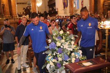 Cristian Álvarez y Jair transportan el centro floral que posteriormente depositarán a los pies de la Virgen del Pilar.