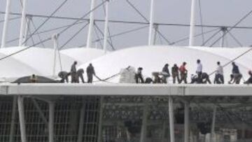 Operarios se afanan en achicar el resto del agua en la parte de la cubierta que ha quedado intacta.