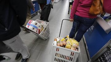 Imagen de varias personas portando un carrito de la compra en un supermercado.