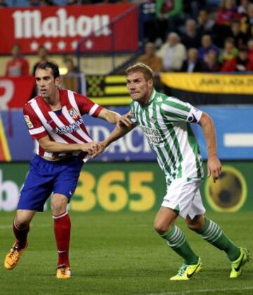 El defensa uruguayo del Atlético de Madrid Diego Godín y el defensa polaco del Real Betis Damien Perquis, durante el encuentro correspondiente a la décima jornada de primera división, que disputan esta noche en el estadio Vicente Calderón de Madrid.