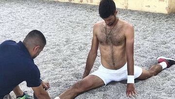 Ulises Badio realiza un estiramiento a Djokovic.