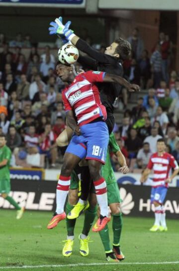 El delantero mexicano del Granada Jhon Córdoba salta por un balón con el portero Jesús Fernández, del Levante, durante el partido de Liga en Primera División disputado esta noche en el estadio Nuevo Los Cármenes, en Granada.