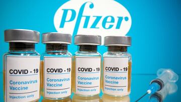 FILE PHOTO: Vials with a sticker reading, "COVID-19 / Coronavirus vaccine / Injection only" and a medical syringe are seen in front of a displayed Pfizer logo in this illustration taken October 31, 2020. REUTERS/Dado Ruvic/Illustration/File Photo