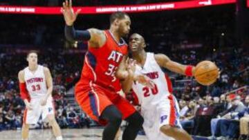 Jodie Meeks trata de superar a Mike Scott, el mejor en el decimotercer triunfo consecutivo de los Hawks.