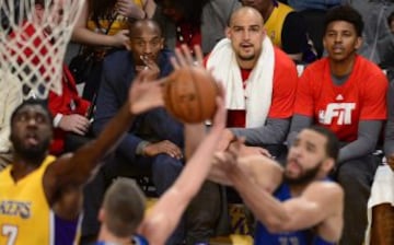 Kobe Bryant observa desde el banquillo a sus Lakers contra los Dallas Mavericks.