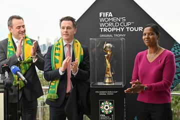 Former golakeeper Briana Scurry of the United States (R) and Australia's New South Wales Premier Chris Minns (C) unveil the trophy for the Australia and New Zealand 2023 Women's World Cup