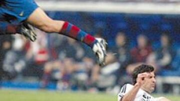 <b>POR EL AIRE</b>. Carles Puyol sale lanzado, mientras Luis Figo queda en el suelo. El defensa resultó lesionado.