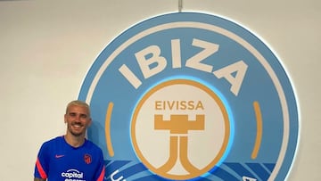 El jugador del Atlético de Madrid Antoine Griezmann posa junto al escudo del Ibiza.