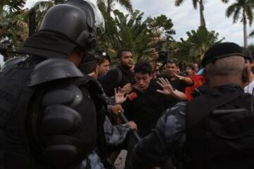 La policía intenta proteger el autobús en el que viajan los jugadores de la selección brasileña de fútbol durante una protesta de maestros de Río de Janeiro.