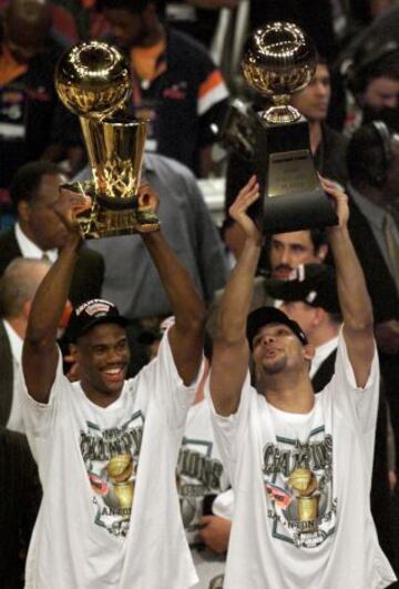 Tim Robinson, con el trofeo de campeón, y Tim Duncan, con el de MVP, en las Finales de 1999.