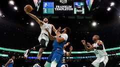 Boston Celtics forward Jayson Tatum (0) goes to the basket over Minnesota Timberwolves center Karl-Anthony Towns (32).