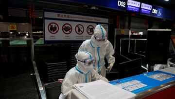 FILE PHOTO: Airline staff wear personal protective equipment (PPE) to protect against coronavirus disease (COVID-19) disease as they work at Beijing Capital International airport in Beijing, China March 13, 2022. REUTERS/Soe Zeya Tun/File Photo