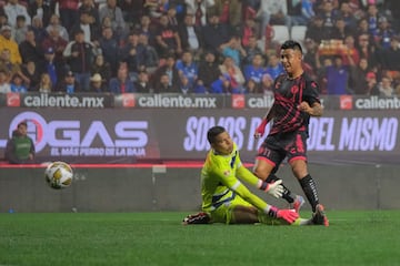 Tijuana's US midfielder #11 Efrain Alvarez strikes the ball and scores a goal past Cruz Azul's Colombian goalkeeper #23 Kevin Mier during the first leg of the Liga MX Apertura tournament quarterfinal football match between Tijuana and Cruz Azul at Caliente Stadium in Tijuana, Baja California State, Mexico, on November 27, 2024. (Photo by Guillermo Arias / AFP)