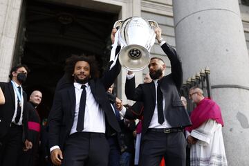 Los capitanes del Real Madrid Marcelo (i) y Karim Benzema (d) muestran a los aficionados el trofeo a la salida de la Catedral de la Almudena.
