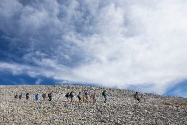 El Mont Ventoux es una de las cimas más emblemáticas del Tour, no solo por la dificultad de sus rampas, sino por lo característico del paisaje que le rodea: un mar de rocas calcáreas, sin vegetación alguna. En la imagen, un grupo de aficionados, algunos con la bici al hombro, camina entre las piedras en busca del mejor lugar para ver el final de la etapa del día 22.
