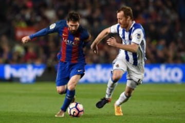 Barcelona's Argentinian forward Lionel Messi (L) vies with Real Sociedad's midfielder David Zurutuza (R) during the Spanish league football match FC Barcelona vs Real Sociedad at the Camp Nou stadium in Barcelona on April 15, 2017. / AFP PHOTO / LLUIS GEN