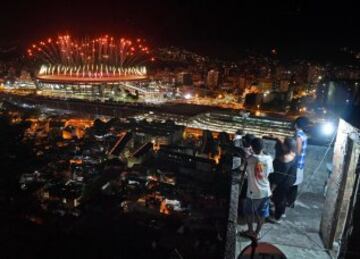 Un grupo de aficionados observan la ceremonia de inauguración de los Juegos Olímpicos de Rio 2016 desde la terraza de una favela de Mangueira.