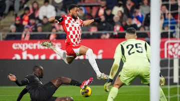 El delantero neerlandés del Girona, Arnaut Danjuma (2i), salta ante el defensa francés del Valencia, Mouctar Diakhaby, durante el encuentro correspondiente a la jornada 28 de Laliga EA Sports que disputan hoy sábado Girona y Valencia en el estadio Montilivi de la capital gerundense.