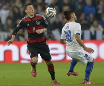 El centrocampista alemán Mesut Özil  y el defensa de Chile Gonzalo Jara compiten por el balón durante el partido de fútbol amistoso entre Alemania y Chile en el Mercedes-Benz Arena