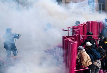 La policía dispersa a los manifestantes después de que bloquearon una calle con una barricada durante una protesta contra las redadas federales de inmigración en el centro de Los Ángeles.