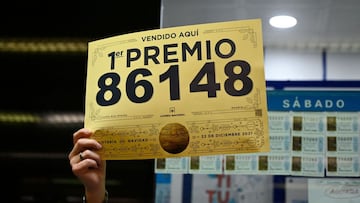 A lottery seller celebrates selling the winning ticket of the first prize of Spain's Christmas lottery in Madrid on December 22, 2021.