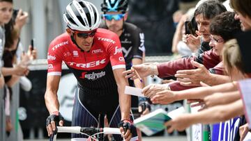 Spain&#039;s Alberto Contador rides towards the start line past supporters asking for autographs prior to the 171 km second stage of the 69th edition of the Criterium du Dauphine cycling race on June 5, 2017 between Saint-Chamond and Arlanc.
  / AFP PHOTO / PHILIPPE LOPEZ