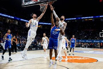 Rudy y Poirier tratan de frenar a Dunston debajo del aro.