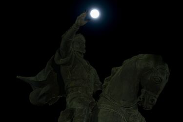 La Luna Llena se eleva sobre el cielo creando una escena impactante con la estatua del Emir Timur en Tashkent, Uzbekistán.