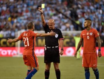 Marcelo Díaz (L) is yellow-carded by Brazilian referee Heber Lopes after fouling Argentina's Lionel Messi during the Copa America Centenario final in East Rutherford, New Jersey, United States, on June 26, 2016.  / AFP PHOTO / Omar Torres