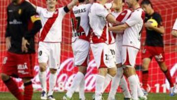 Los jugadores del Rayo Vallecano celebran el primer gol de su equipo, materializado por el delantero brasile&ntilde;o Leo Baptistao, en presencia del centrocampista del Mallorca, V&iacute;ctor Casades&uacute;s (i), durante el partido correspondiente a la decimotercera jornada de la Liga de Primera Divisi&oacute;n disputado en el estadio municipal de Vallecas.