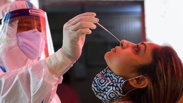 A medical worker collects a swab sample from awoman for a RT-PCR Covid-19 Coronavirus test in Ghaziabad on September  27, 2020. (Photo by Prakash SINGH / AFP)