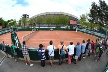 Los aficionados observan un partido en una pista anexa a la pista central.