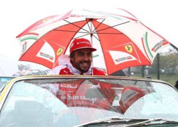 SUZUKA, JAPAN - OCTOBER 05:  Fernando Alonso of Spain and Ferrari takes part in a rain soaked Drivers Parade prior to the Japanese Formula One Grand Prix at Suzuka Circuit on October 5, 2014 in Suzuka, Japan.  (Photo by Mark Thompson/Getty Images)