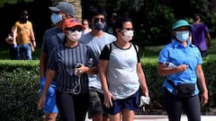 Personas que usan m&aacute;scaras faciales caminan en Lake Eola Park en Orlando, Florida. 