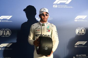 Hamilton posa con el trofeo tras conseguir su pole. 