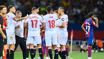 Sevilla's Spanish coach Jose Luis Mendilibar (L) talks with players as Barcelona's Spanish forward #27 Lamine Yamal drinks during the Spanish Liga football match between FC Barcelona and Sevilla FC at the Estadi Olimpic Lluis Companys in Barcelona on September 29, 2023. (Photo by Pau BARRENA / AFP)