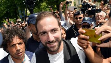 El delantero argentino Gonzalo Higua&iacute;n (c) saluda a los aficionados a su llegada a las oficinas del Juventus en Tur&iacute;n.