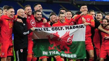 Gareth Bale posa con la bandera en la que se lee "Gales. Golf. Madrid. En ese orden" tras la clasificación de Gales para la Eurocopa.