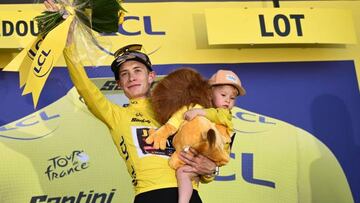 Jumbo-Visma team's Danish rider Jonas Vingegaard holds his daughter Frida as he celebrates with the overall leader's yellow jersey on the podium after the 20th stage of the 109th edition of the Tour de France cycling race, 40,7 km individual time trial between Lacapelle-Marival and Rocamadour, in southwestern France, on July 23, 2022. (Photo by Marco BERTORELLO / AFP) (Photo by MARCO BERTORELLO/AFP via Getty Images)
