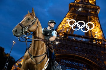 Un policía encima de su caballo delante de la Torre Eiffel iluminada. 