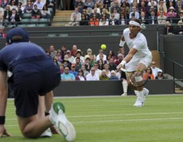 El tenista español Rafael Nadal devuelve la bola al belga Steve Darcis, durante el partido de primera ronda del torneo de tenis de Wimbledon