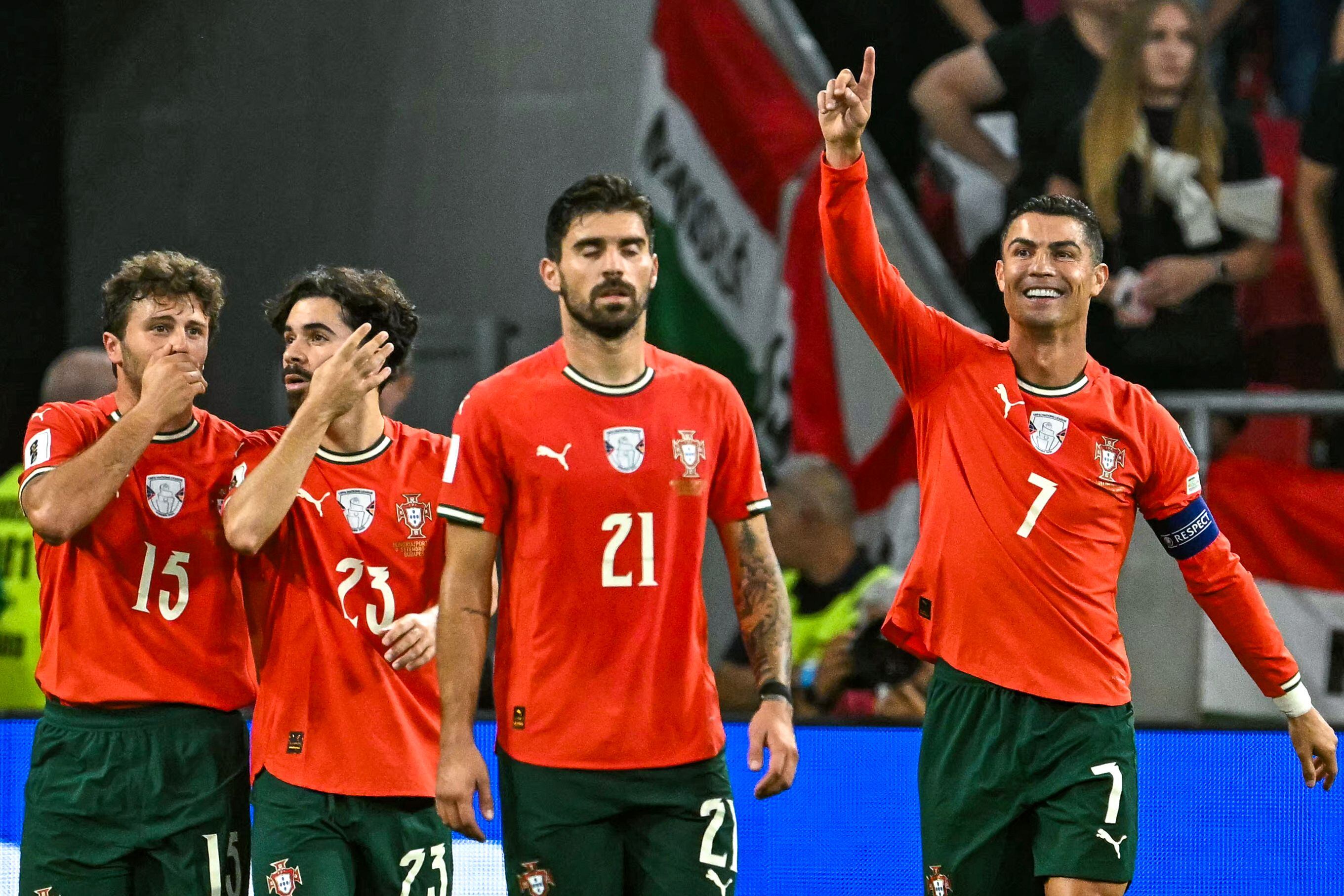 Portugal's forward #07 Cristiano Ronaldo (R) celebrates with team mates after scoring the 1-2 penalty goal during the 2026 World Cup qualifiers Europe zone group F football match between Hungary and Portugal on September 9, 2025 in Budapest, Hungary. (Photo by Attila KISBENEDEK / AFP)